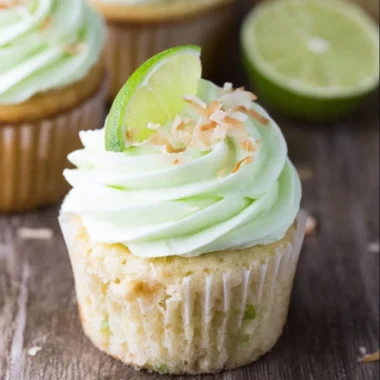 Coconut cupcakes topped with lime buttercream frosting on a decorative plate