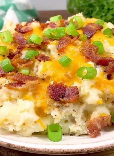 Twice Baked Potato Casserole topped with cheese and chives in a baking dish