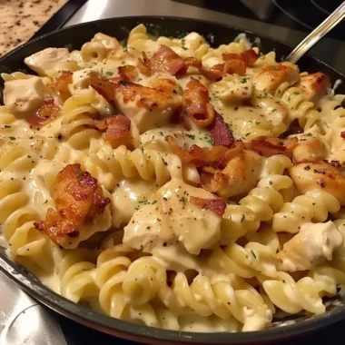Delicious Chicken Bacon Ranch Pasta served in a bowl with herbs and cheese.
