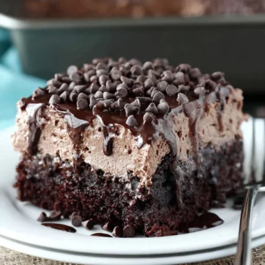 Delicious chocolate poke cake with chocolate drizzle and whipped cream topping.
