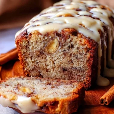 Slice of easy cinnamon roll banana bread with swirls of cinnamon and icing