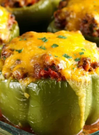 Colorful stuffed peppers filled with rice, beans, and spices, served on a plate.