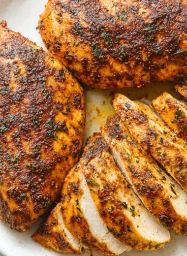 Juicy baked chicken breast served with herbs and spices on a plate