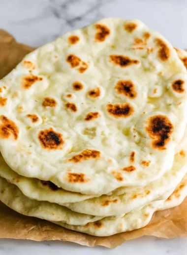 Homemade Greek Pita bread fresh from the oven, ideal for Mediterranean dishes.