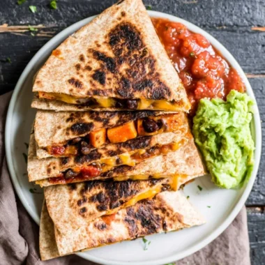 Black Bean Sweet Potato Quesadilla on a plate, garnished with fresh herbs.