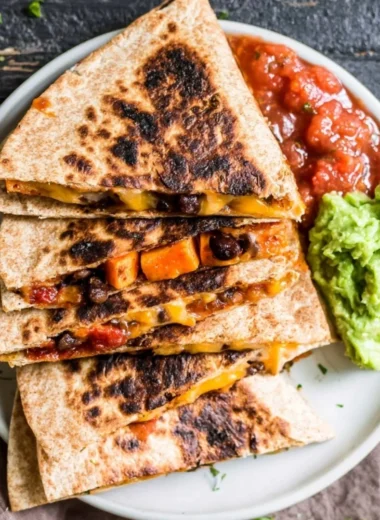 Black Bean Sweet Potato Quesadilla on a plate, garnished with fresh herbs.