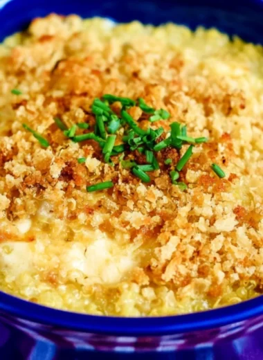 Bowl of cheesy quinoa mac and cheese topped with herbs and cheese