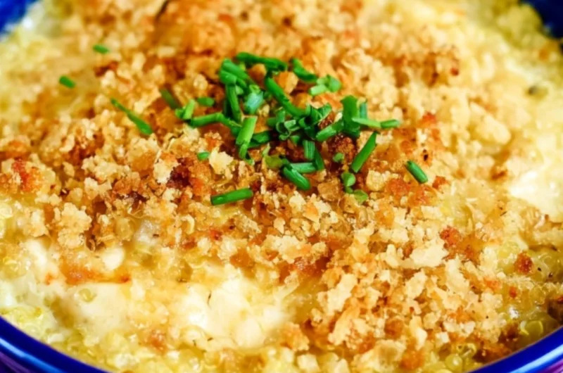 Bowl of cheesy quinoa mac and cheese topped with herbs and cheese