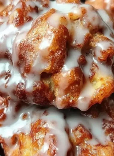 Cinnamon apple fritters topped with sugar glaze and sprinkled with cinnamon