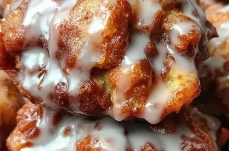 Cinnamon apple fritters topped with sugar glaze and sprinkled with cinnamon