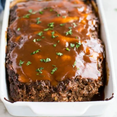 Delicious classic meatloaf served with brown gravy on a plate