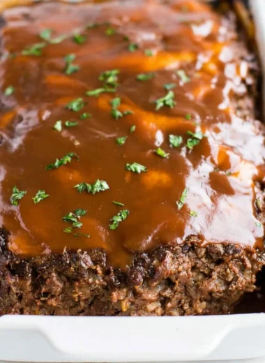Delicious classic meatloaf served with brown gravy on a plate