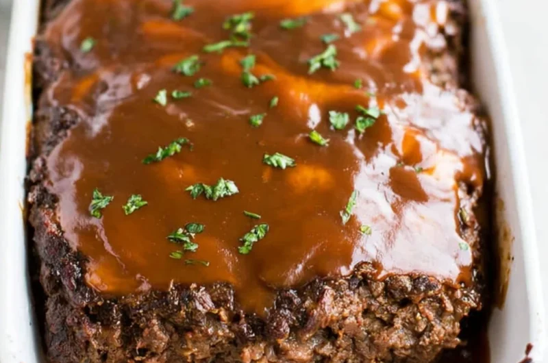 Delicious classic meatloaf served with brown gravy on a plate
