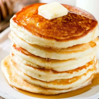 Delicious homemade fluffy pancakes stacked with syrup and berries
