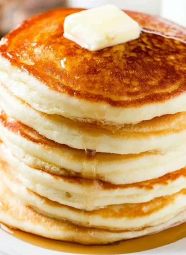Delicious homemade fluffy pancakes stacked with syrup and berries