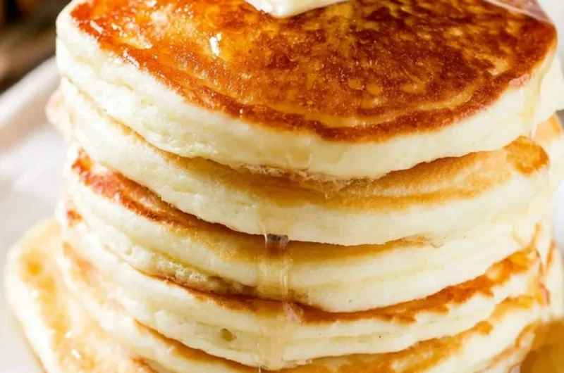 Delicious homemade fluffy pancakes stacked with syrup and berries