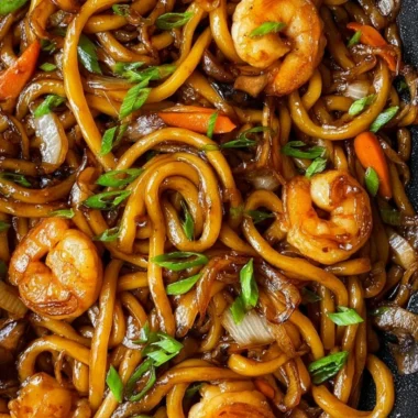 Delicious plate of Fried Udon topped with vegetables and sauce
