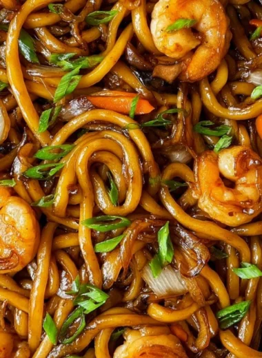 Delicious plate of Fried Udon topped with vegetables and sauce