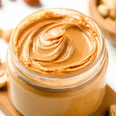 Homemade peanut butter spread with peanuts and a blender