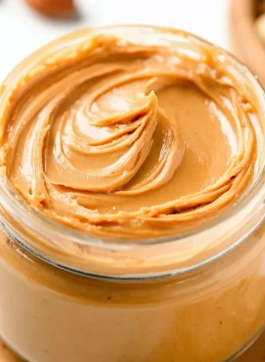 Homemade peanut butter spread with peanuts and a blender