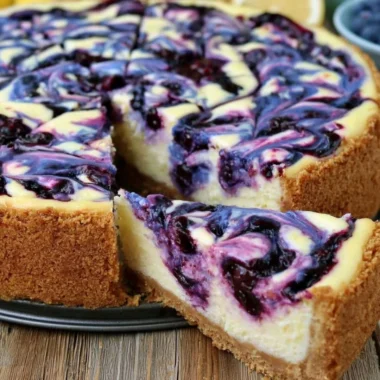 Lemon Blueberry Cheesecake topped with fresh blueberries and lemon zest.