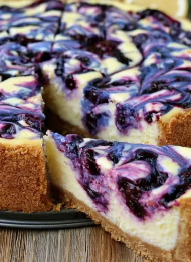 Lemon Blueberry Cheesecake topped with fresh blueberries and lemon zest.