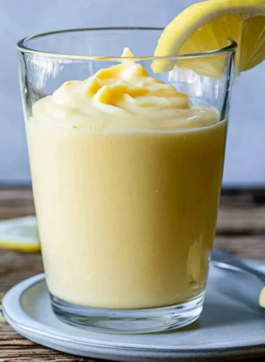 Delicious lemon cream dessert served in a bowl with fresh lemon slices.