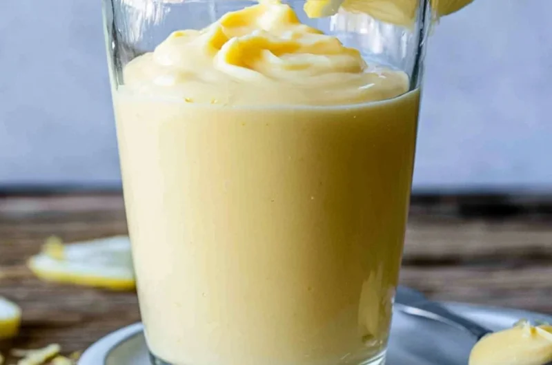 Delicious lemon cream dessert served in a bowl with fresh lemon slices.