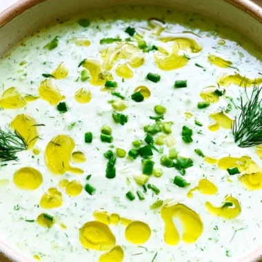 Bowl of no-cook cucumber gazpacho topped with fresh herbs