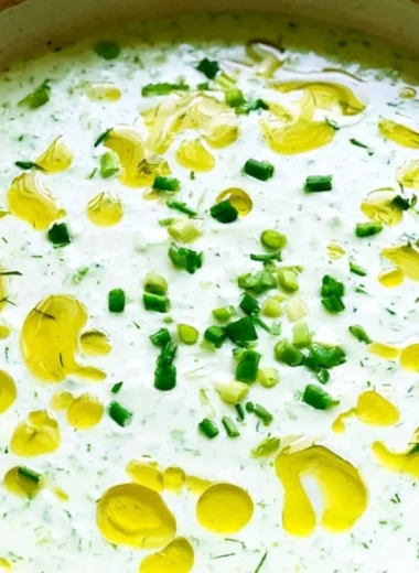 Bowl of no-cook cucumber gazpacho topped with fresh herbs