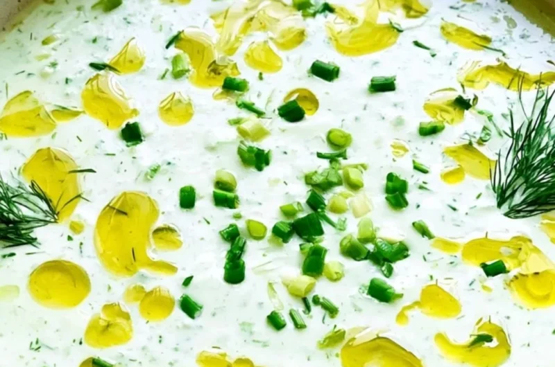 Bowl of no-cook cucumber gazpacho topped with fresh herbs
