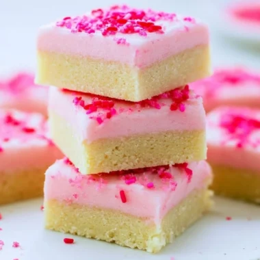 Delicious sugar cookie bars topped with frosting and sprinkles