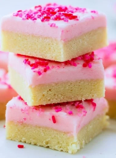 Delicious sugar cookie bars topped with frosting and sprinkles