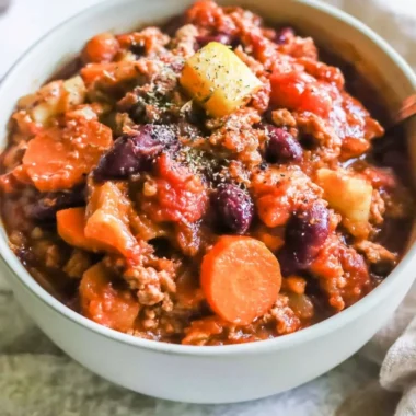 Bowl of Turkey Apple Chili garnished with fresh herbs