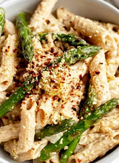 Vegan lemon white bean pasta garnished with fresh herbs.