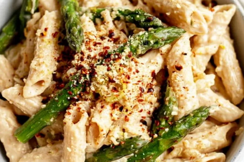 Vegan lemon white bean pasta garnished with fresh herbs.