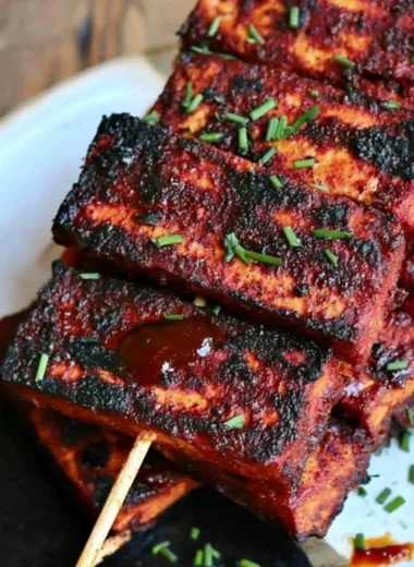 Vegan Sweet and Spicy BBQ Tofu served on a plate with garnishes