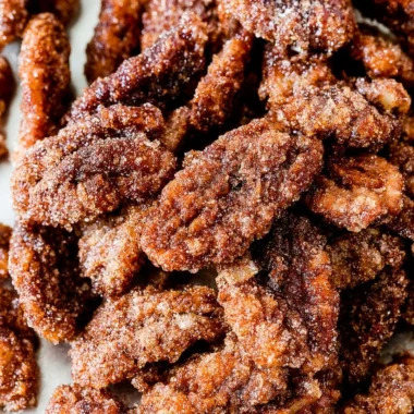 Cinnamon sugar candied pecans in a bowl, a sweet snack or dessert topping.