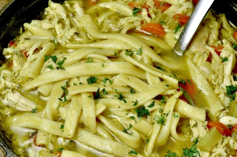 Bowl of cozy homemade chicken noodle soup with vegetables and herbs