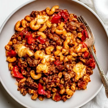 Slow cooker goulash served in a bowl with fresh herbs.