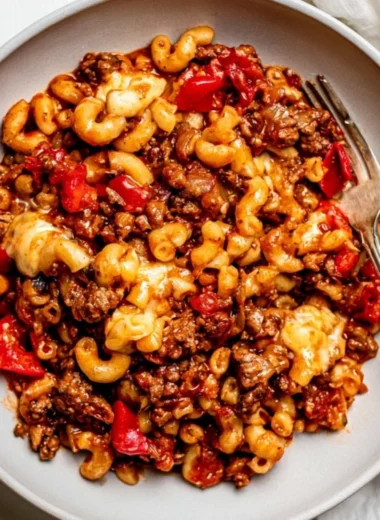 Slow cooker goulash served in a bowl with fresh herbs.