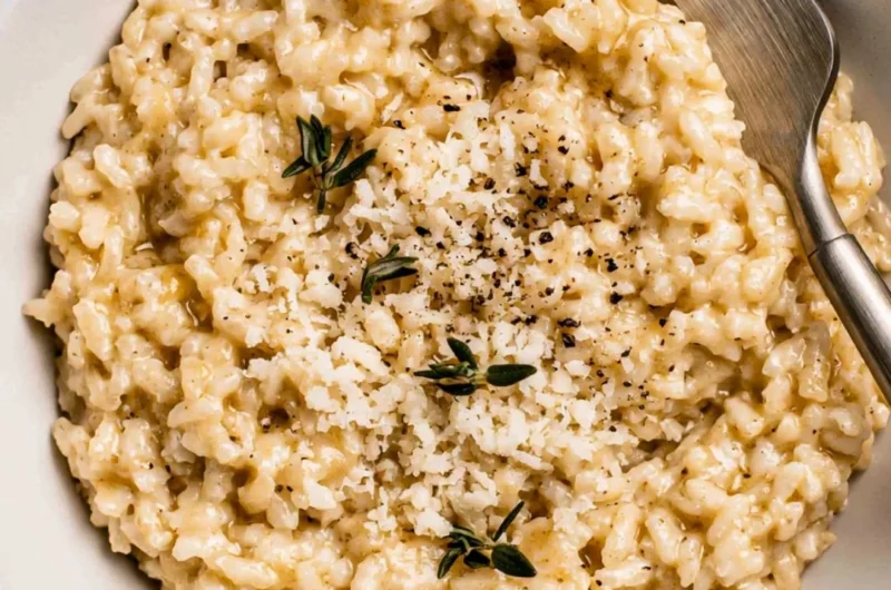 Plate of creamy risotto garnished with herbs and grated cheese