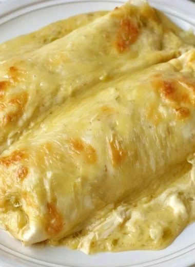 Delicious creamy white chicken enchiladas garnished with cilantro on a plate.