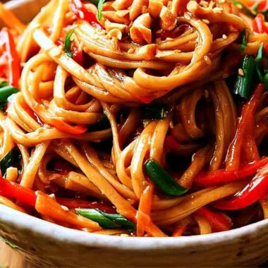 Bowl of easy Thai noodles garnished with peanut sauce and vegetables
