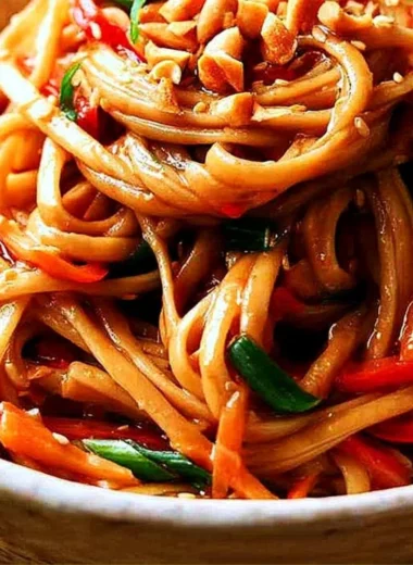 Bowl of easy Thai noodles garnished with peanut sauce and vegetables