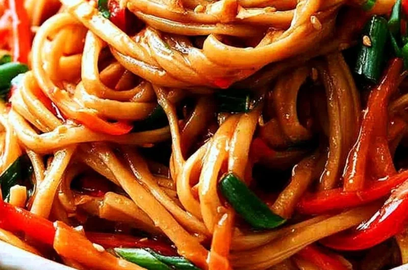 Bowl of easy Thai noodles garnished with peanut sauce and vegetables