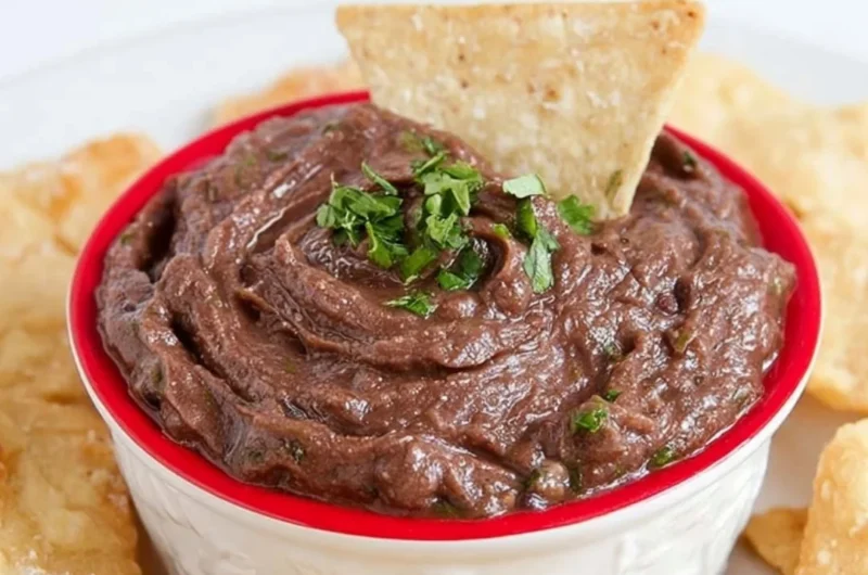 Quick and easy vegan black bean dip served in a bowl with tortilla chips