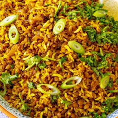 Bowl of Mediterranean lentils and rice with fresh herbs and vegetables