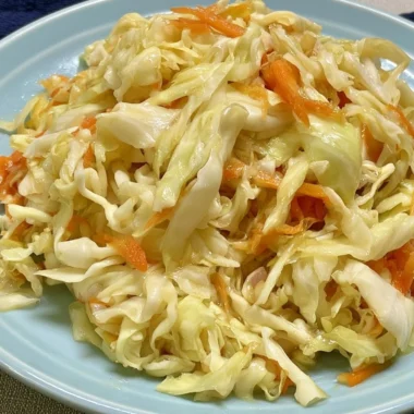 Bowl of fresh vinegar and oil coleslaw topped with herbs