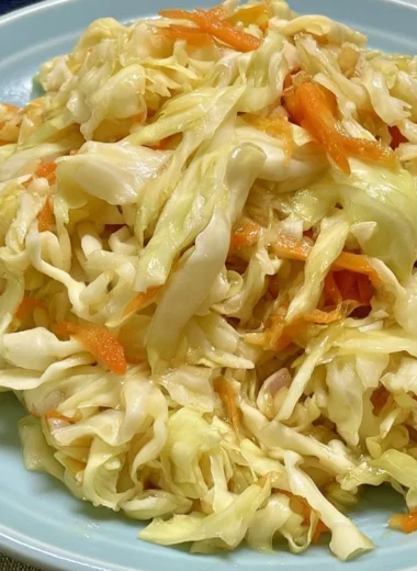 Bowl of fresh vinegar and oil coleslaw topped with herbs